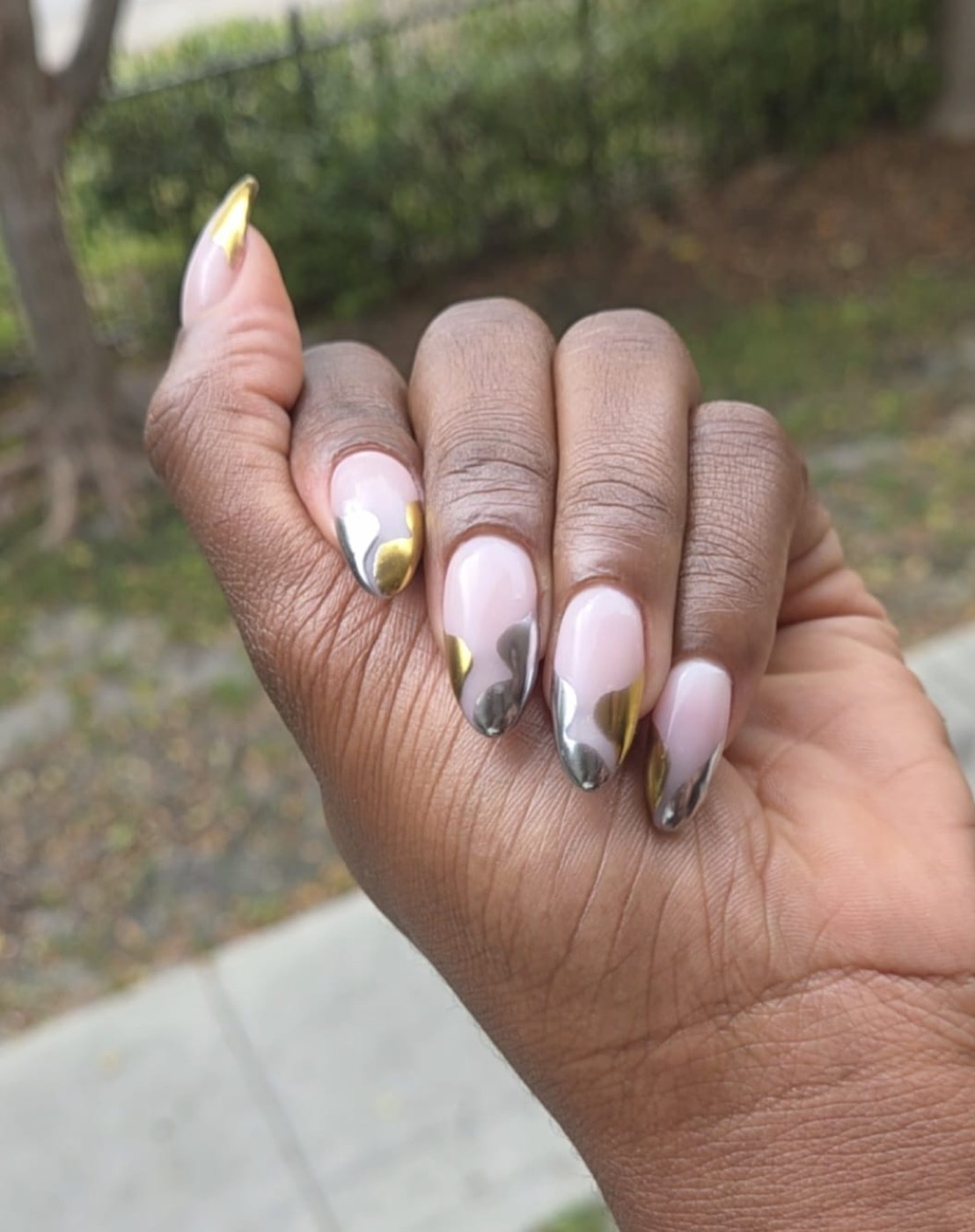 Almond nails with gold and silver chrome heart shaped French tips