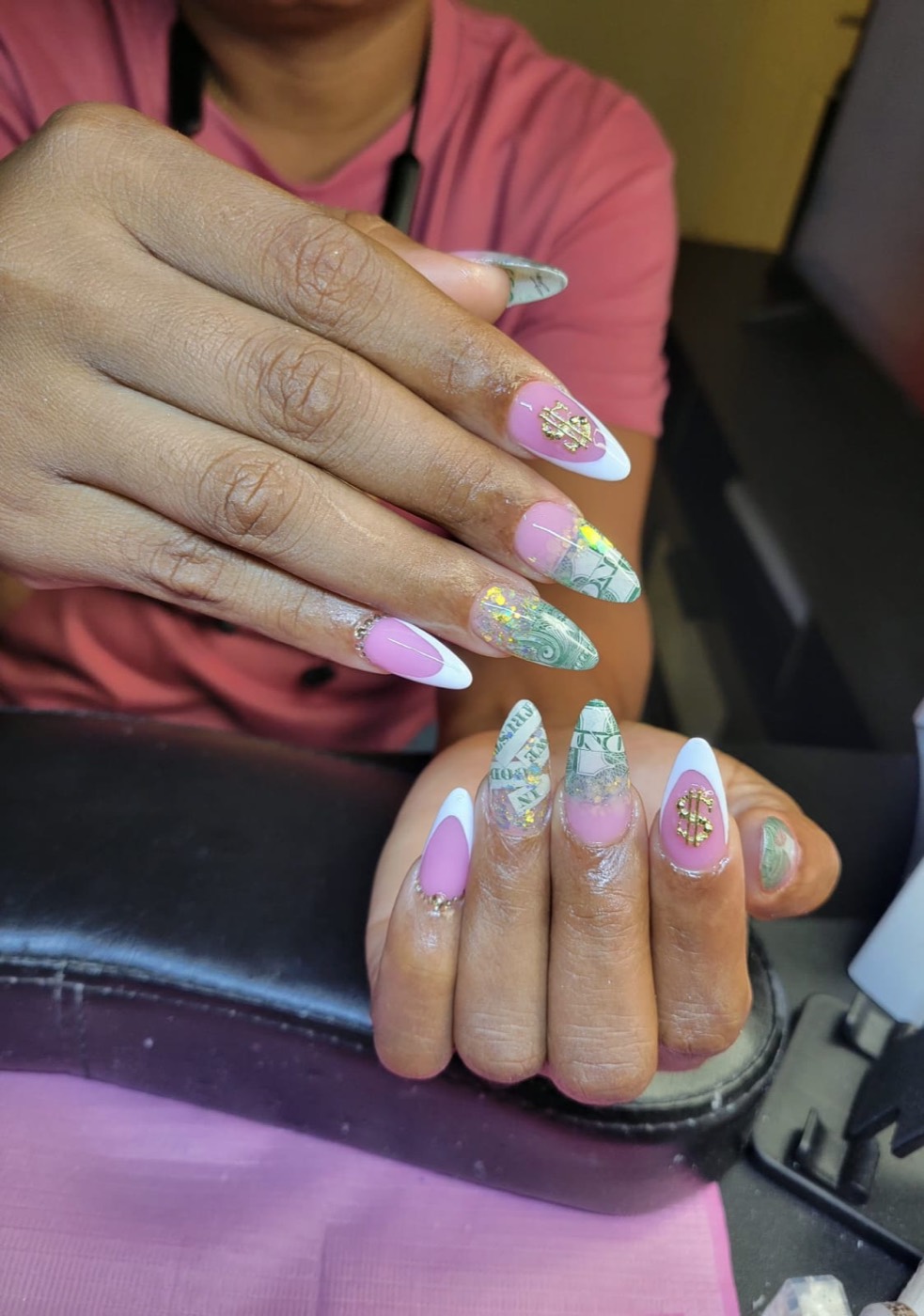 Stiletto nails with pink and white French tips, dollar bill art, and gold flake accents