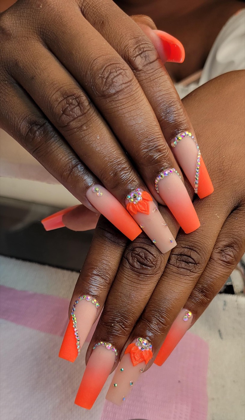 Extra long neon orange coffin nails with rhinestone edges and 3D roses